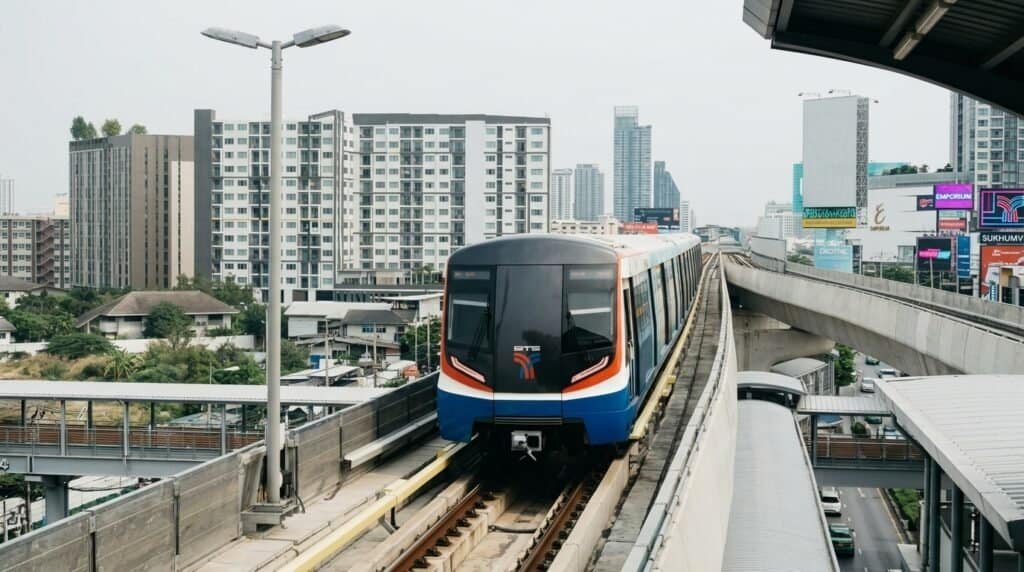 Getting Around Bangkok Guide BTS Skytrain running above a busy Bangkok street at dusk